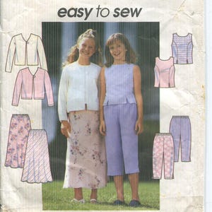 Puede incluir: Patrón Simplicity 8550 para ropa de niña. El patrón incluye opciones para una falda, pantalones y tops. La imagen muestra a dos niñas modelando la ropa. Se muestra el texto "easy to sew".