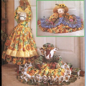 May include: Simplicity Crafts pattern 8872 featuring three decorative doll designs. The dolls are dressed in sunflower and gingham print fabric. One doll has a horse head, another a pig head, and the third a doll with a straw hat.