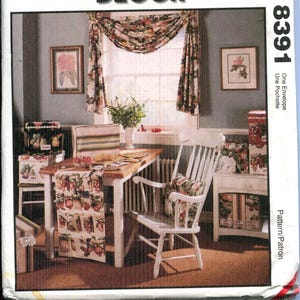 May include: McCall's Creative Decor pattern envelope. The image shows a dining room scene with a table, chairs, and window treatments. The table has a fruit-themed runner. The room is decorated with floral accents and framed artwork.