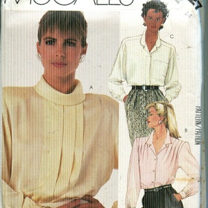 May include: McCall's sewing pattern 2227 featuring three blouse designs. The pattern includes a variety of styles, including a collared blouse and a high-neck blouse. The package features illustrations of the finished garments.