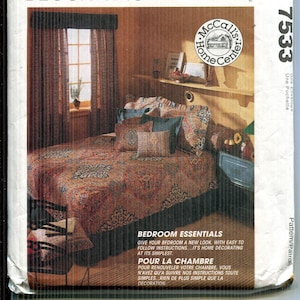 May include: McCall's Home Decorating pattern envelope showing a bedroom scene with a bed, window, and curtains. The envelope has text that reads "Bedroom Essentials" and "Give your bedroom a new look."