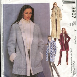 May include: McCall's sewing pattern featuring a woman in a light gray coat with a cream-colored lining. The pattern includes designs for various coat styles, with the number 3807 and the size Z visible.