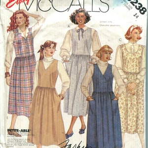 Pode incluir: Um envelope de molde de costura McCall's 3238 com ilustrações de cinco estilos diferentes de vestidos tipo jardineira. Os designs incluem vários tecidos xadrez, lisos e florais, combinados com camisas de manga comprida. O texto inclui Easy McCall's 3238.