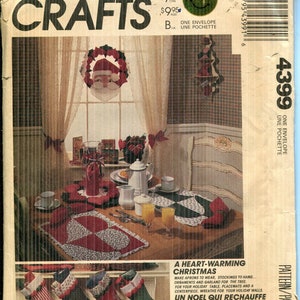 May include: McCall's Crafts pattern envelope featuring a Christmas theme. The image shows a decorated table with a Santa Claus wreath, stockings, and a table setting. The text reads "A Heart-Warming Christmas."