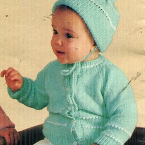 Könnte beinhalten: Eine hell mintgrüne Strickjacke mit passender Mütze mit Bommel. Die Strickjacke hat lange Ärmel, einen Rundhalsausschnitt und eine Knopfleiste auf der Vorderseite. Sie ist mit dünnen weißen horizontalen Streifen an Ärmeln und Taille verziert.