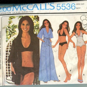 Op de afbeelding: Vintage McCall's 5536 naaipatroon voor dames cover-up, badpak en bikini. Het patroon toont illustraties van een zwarte cover-up, een blauwe jurk, een zwarte bikini en een wit badpak met patroon. Maat 10, borstomvang 82.5 cm.