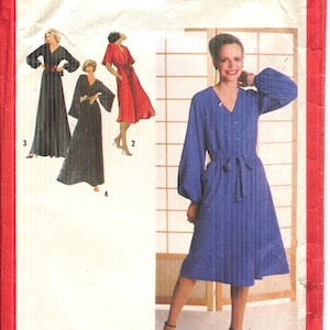 May include: Simplicity 2212 sewing pattern envelope. The cover features illustrations of dresses in black and red, and a woman in a blue dress. The blue dress has long sleeves and a tie waist. Size 10 Miss.
