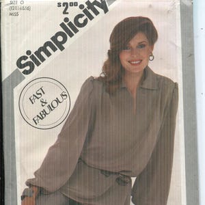 Puede incluir: Sobre de patrón Simplicity con una mujer con un traje color taupe. El sobre incluye el texto "Simplicity Today" y "Fast & Fabulous". El número de patrón es 5214, y la talla es O (12, 14 y 16).