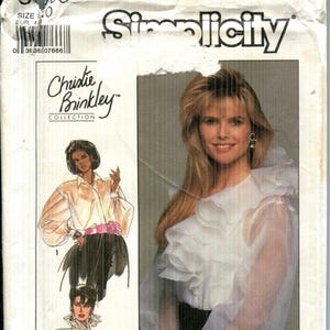 May include: Simplicity pattern envelope featuring a Christie Brinkley Collection design. The envelope displays a woman in a white blouse with ruffles and illustrations of similar blouses. The pattern number is 8903, size 20.