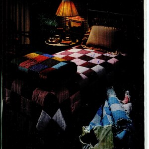 May include: An advertisement for "Fatt Batt Comforters" featuring a bed with a patchwork quilt in shades of red, blue, and yellow. The image includes text that reads "Complete Instructions for Comforters" and lists sizes: Crib/Craft (45" x 60"), Twin (72" x 90"), and Full/Queen (81" x 96").