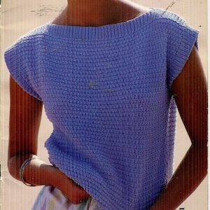 May include: A light blue knitted sleeveless top with a boat neck.