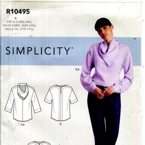 May include: Simplicity pattern R10495 features a woman wearing a lilac blouse and dark blue pants. The pattern includes illustrations of different blouse styles. The pattern size ranges from XXS to XXL.