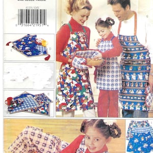 May include: Butterick 4119 sewing pattern envelope featuring illustrations of aprons, oven mitts, and a bear-shaped pillow. The designs showcase blue fabric with snowman and holiday patterns, alongside blue and white checkered fabric accents.