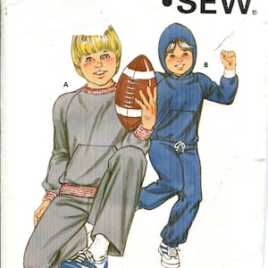 Op de afbeelding: Een vintage Kwik Sew patroon met illustraties van kinderen in sportkleding. Eén kind draagt een grijze trainingspak en houdt een voetbal vast, de ander draagt een blauw trainingspak met capuchon. Het patroonnummer is 1149.