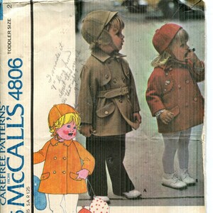 May include: McCall's 4806 sewing pattern for a toddler's coat and hat. The envelope features illustrations and photographs of children wearing double-breasted coats with collars, pockets, and matching hats in tan, red, and orange colour variations.