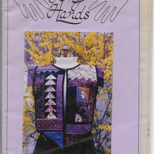 以下が含まれることがあります： 「To My Hands」というタイトルのソーイングパターンで、サンプラーベストが特徴です。 ベストはマネキンに表示されており、紫、黒、白の色合いのパッチワークデザインです。 「Sampler Vest」と「Ladies' sizes 6-20」の文字も表示されています。