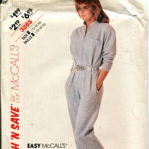 May include: McCall's sewing pattern for a jumpsuit. The pattern features a woman wearing a light gray jumpsuit with a zipper front, a belt, and pockets. The pattern number is 3285, and the size is B (12-14-16).