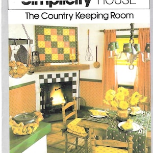 May include: A vintage interior scene featuring a cozy country kitchen. The room includes a fireplace, a dining table set for a meal, and a decorative quilt. The color palette is warm, with yellows, greens, and oranges.