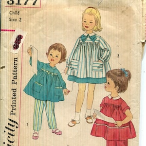 May include: A vintage Simplicity pattern envelope, featuring illustrations of three children in dresses and trousers. The envelope is tan with the number 3177 and the text "Child Size 2".