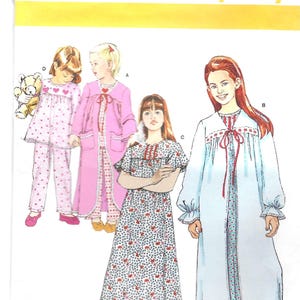 May include: Simplicity sewing pattern 1569 KK for girls' sleepwear, sizes 7-12. The pattern includes designs for pajamas, a robe, and a nightgown. The image shows illustrations of the finished garments in various colors and patterns.
