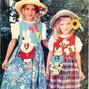 May include: A vintage sewing pattern for a children's "Pet Pocket Jumper" dress. The image shows two girls modelling the dresses, one with a bunny and butterfly design, the other with bees and a cat. The dresses have pockets.
