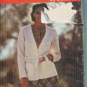 Op de afbeelding: Vintage Butterick See & Sew patroonhoes. De hoes toont een vrouw in een crèmekleurig jasje met een strik in de taille en een geruite rok. De tekst "See & Sew" en patroonnummer 6638 zijn zichtbaar.