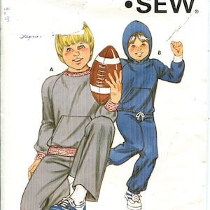 May include: A vintage Kwik Sew pattern, number 1149, showing illustrations of children's athletic clothing. One child is in a grey tracksuit holding a football, the other in a blue hooded tracksuit. Sizes 4-7 are included.