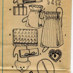 May include: Vintage McCall's sewing pattern featuring various bag designs, including drawstring pouches, a heart-shaped applique, and a teddy bear-shaped item. The pattern includes the number 7378.
