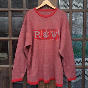 以下が含まれることがあります： 赤いニットセーターにグレーの「R.S.W.」ロゴが前面にプリントされています。