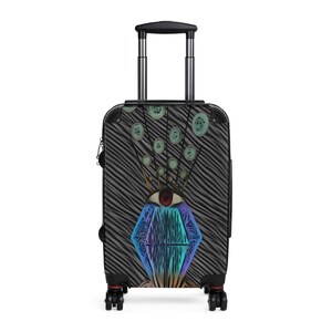 May include: Black suitcase with a colorful abstract design featuring a large diamond shape with an eye in the center. The design is reminiscent of a peacock's tail feathers.