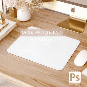 May include: White desk mouse pad mockup on a wooden desk with a gold computer stand, a vase of white flowers, and a white mouse. The text "DESK MOUSE PAD mockup" is visible on the mouse pad.