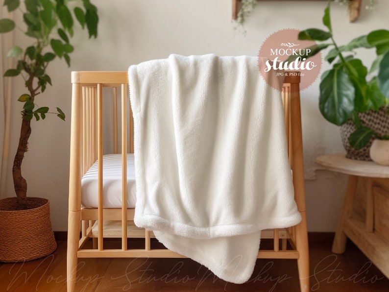 May include: White plush blanket draped over a wooden crib with a white mattress. The crib is in a room with a plant in a woven basket and a wooden side table.