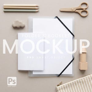 May include: A mockup featuring a white folder and booklet with the word "MOCKUP" in large white letters. The image includes pencils, scissors, a cloud-shaped object, wooden blocks, and a striped pouch. The text "FOLDER & BOOKLET" and "PSD SMART OBJECT" are also visible.