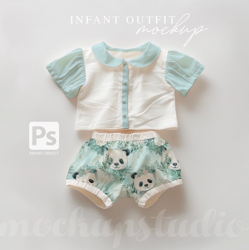 May include: A white and light blue baby outfit with a collared shirt and panda print shorts. The shirt has a button closure and the shorts have an elastic waistband. The outfit is laid flat on a white background.