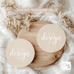 May include: Two round wooden signs with the text "Your design here" in white script on a light brown wooden surface. The signs are on a white fabric background.
