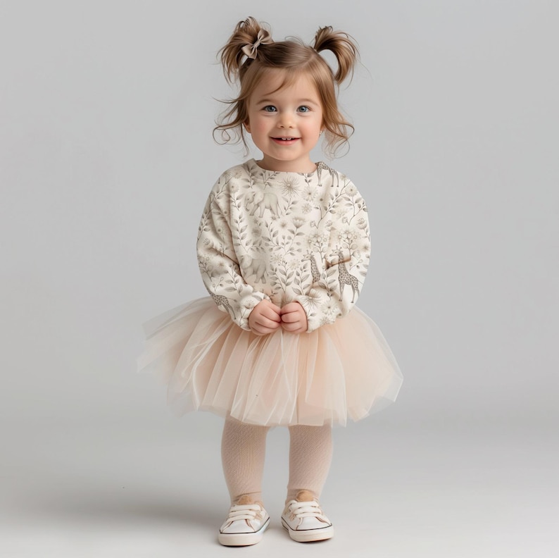 May include: A young girl wearing a cream-colored sweatshirt with a floral and giraffe print, a tulle tutu skirt, and white sneakers.