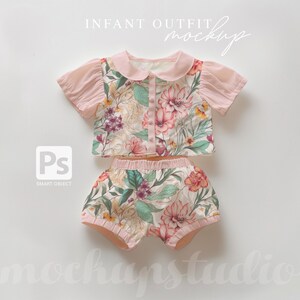 May include: A pink and white floral print baby outfit with a collared top and bloomers. The top has a button closure and short sleeves. The bloomers have a ruffled hem.
