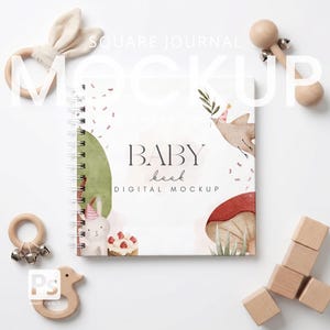 May include: A square baby book mockup with a spiral binding, surrounded by wooden toys. The book cover features watercolour illustrations of a bunny, cake, and a bird. The text on the cover reads "BABY book" and "DIGITAL MOCKUP".
