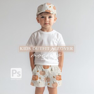 May include: A child wearing a white t-shirt and pumpkin-patterned shorts with a white and orange pumpkin-patterned baseball cap. "KIDS OUTFIT ALLOVER MOCKUP" is written in the image.