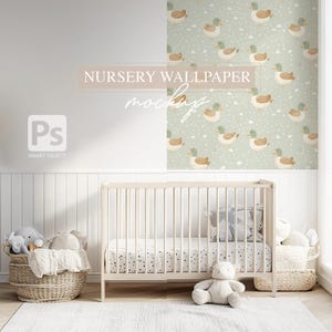 K&ouml;nnte beinhalten: Ein wei&szlig;es Babybett mit einem wei&szlig;en und schwarzen gemusterten Laken und einem wei&szlig;en Teddyb&auml;ren, der davor sitzt. Die Wand hinter dem Babybett ist mit einer gr&uuml;n-wei&szlig;en Tapete mit einem sich wiederholenden Muster aus braunen Enten verziert.