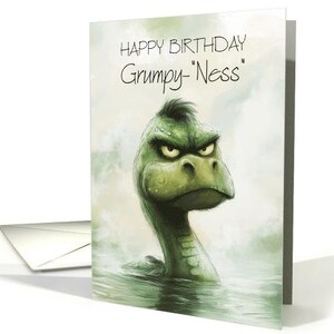 May include: A green monster with a grumpy expression is shown on a birthday card. The card reads "Happy Birthday Grumpy-Ness".