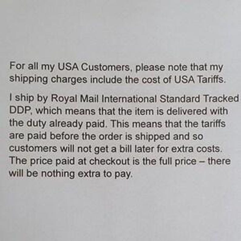 May include: A white document featuring black printed text that explains shipping policies for USA customers, specifically detailing that tariffs are included in the shipping charges and that all duties are paid prior to the order being shipped.