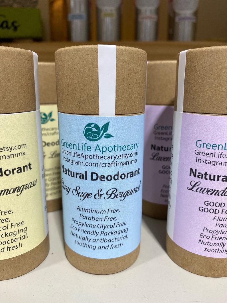 Op de afbeelding: Drie natuurlijke deodorantbuizen met bruine kartonnen verpakking. De middelste buis is gelabeld "GreenLife Apothecary Natural Deodorant Clay Sage & Bergamot" en vermeldt de ingredi&euml;nten. De linker buis is gelabeld "Lemongrass Deodorant" en de rechter buis is gelabeld "Natural Lavender Deodorant".