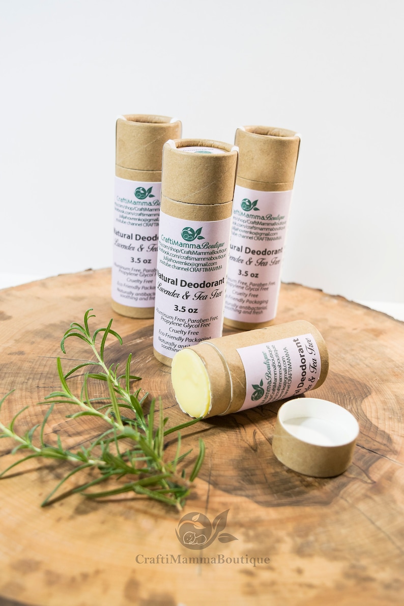 Op de afbeelding: Drie bruine kartonnen buizen met natuurlijke deodorant met lavendel- en theeboomolie. De buizen zijn gelabeld met "Natural Deodorant Lavender & Tea Tree" en vermelden de ingredi&euml;nten, waaronder "Aluminiumvrij, Parabenvrij, Propylenglycolvrij, Milieuvriendelijke verpakking, Dierproefvrij, Natuurlijk antibacterieel, Kalmerend en fris". De buizen zijn elk 3,5 oz.