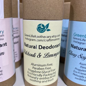 Op de afbeelding: Drie kartonnen buizen met etiketten voor natuurlijke deodorant. De etiketten zijn cr&egrave;me, geel en lichtblauw. De tekst op het gele etiket luidt "Natuurlijke deodorant Patchouli & Lemongrass Aluminiumvrij, Parabenvrij, Propylenglycolvrij Milieuvriendelijke verpakking Natuurlijk antibacterieel verzachtend en fris". De tekst op het lichtblauwe etiket luidt "Natuurlijke deodorant Clary Sage Aluminium Paraben Propylenglycol Milieuvriendelijk Natuurlijk verzachtend".
