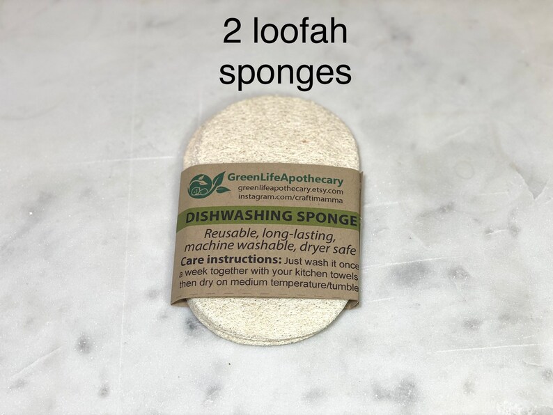 May include: Two natural loofah sponges with a brown paper label that reads "GreenLifeApothecary" and "DISHWASHING SPONGE". The label also includes care instructions for the sponges.