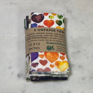 May include: A stack of six colorful unpaper towels with a heart pattern. The towels are 10 inches by 10 inches and are made of 100% cotton. The packaging includes care instructions and the brand name "GreenLifeApot".