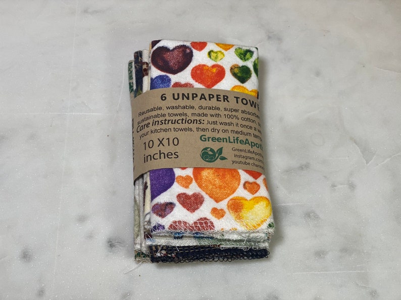 May include: A stack of six colorful unpaper towels with a heart pattern. The towels are 10 inches by 10 inches and are made of 100% cotton. The packaging includes care instructions and the brand name "GreenLifeApot".