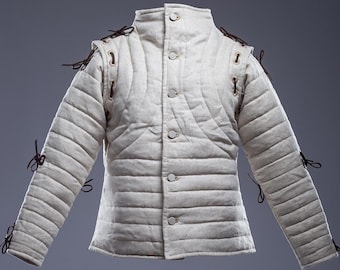 Puede incluir: Una chaqueta acolchada blanca con detalles de cordones de cuero marrón. La chaqueta tiene un cuello alto y cierre de botones.