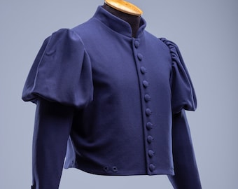 Puede incluir: Una chaqueta azul marino recortada con mangas abullonadas y una fila de botones en la parte delantera. La chaqueta tiene un cuello alto y está hecha de una tela gruesa y texturizada.